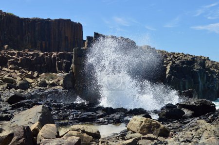 Ein Blick auf Wellen, die bei Bombo an der Südküste von New South Wales, Australien, gegen Felsformationen krachen