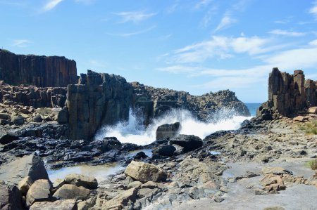 Una vista de las olas que se estrellan contra formaciones rocosas en Bombo en la costa sur de Nueva Gales del Sur, Australia