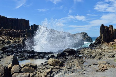 Ein Blick auf Wellen, die bei Bombo an der Südküste von New South Wales, Australien, gegen Felsformationen krachen