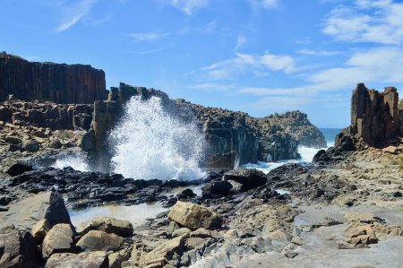 A view of waves crashing against rock formations at Bombo on the South Coast of New South Wales, Australia