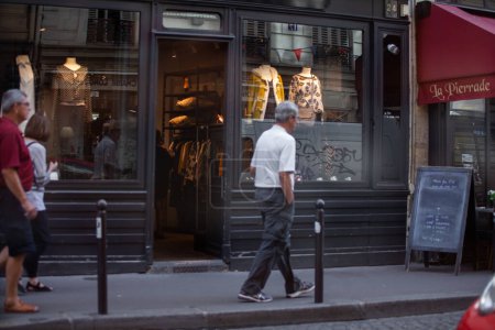 Téléchargez les photos : Hommes marchant à travers une vitrine dans le quartier historique de Paris, France - en image libre de droit