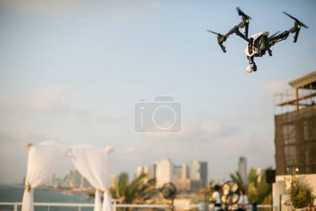 Téléchargez les photos : Drone planant dans le ciel au-dessus du chuppah avant la cérémonie de mariage juive dans le contexte de la mer - en image libre de droit