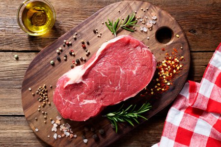 Téléchargez les photos : Steak de bœuf cru frais avec des épices sur fond en bois. vue de dessus - en image libre de droit