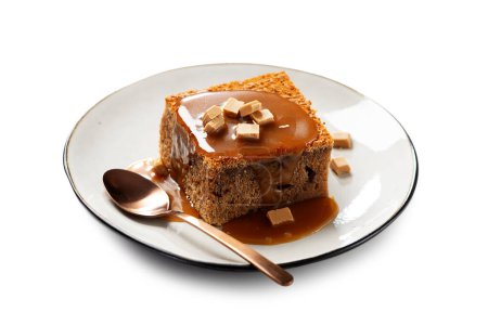 Téléchargez les photos : Easy Sticky Toffee Pudding est un gâteau éponge délicieusement gluant trempé dans la sauce au caramel chaud thats un favori parmi les Anglais. isolé sur fond blanc - en image libre de droit