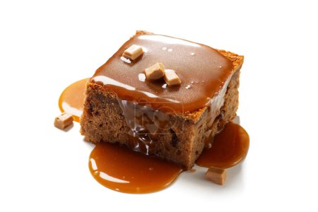 Téléchargez les photos : Easy Sticky Toffee Pudding is a deliciously gooey sponge cake drenched in warm toffee sauce thats a favorite among the English. isolated on white background - en image libre de droit