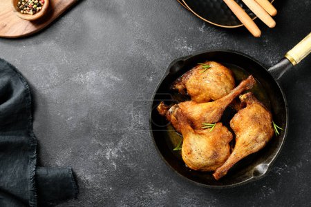 Téléchargez les photos : Jambes de canard fraîchement rôties confit dans une casserole, vue sur le dessus, fond noir - en image libre de droit