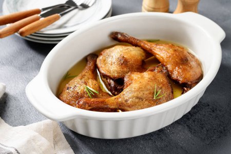 Photo for Freshly roasted duck legs confit in oven pan. - Royalty Free Image
