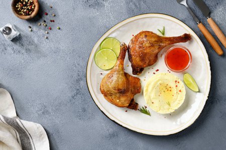 Photo for Freshly roasted duck legs confit served with potato puree and lime slices. top view - Royalty Free Image