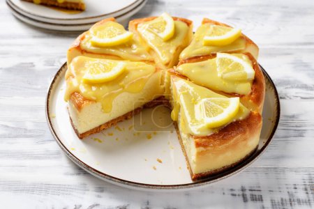 Téléchargez les photos : Gâteau au fromage au citron frais et cuit au four avec du caillé de citron et des tranches de citron. - en image libre de droit