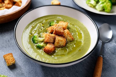 Bowl of fresh broccoli cream soup with croutons.