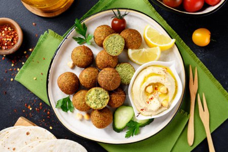 Téléchargez les photos : Assiette de boules de falafel aux pois chiches avec houmous, légumes et tranches de citron.. - en image libre de droit