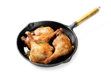 Téléchargez les photos : Jambes de canard fraîchement rôties confites dans une casserole en fer, isolées sur fond blanc. - en image libre de droit