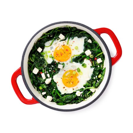 Photo for Green shakshuka with fresh spinach, fried eggs and feta cheese cubes, healthy breakfast. isolated on white background, top view - Royalty Free Image