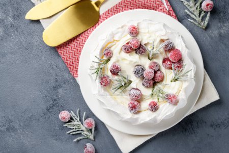 Photo for Pavlova meringue cake decorated with frozen cranberry and rosemary. Cake for christmas event. top view - Royalty Free Image