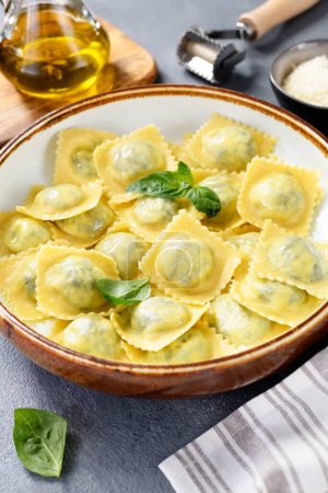 Photo for Homemade Ravioli pasta with spinach and ricotta cheese filling with olive oil and grated Parmesan cheese. - Royalty Free Image