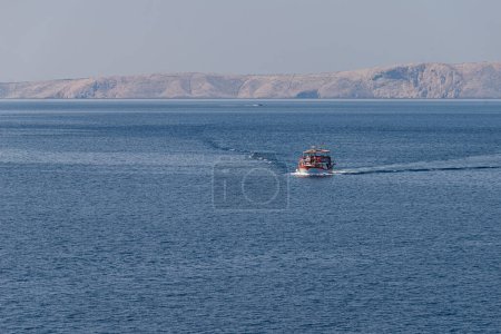 Téléchargez les photos : Photo de bateau d'excursion avec touriste allant de l'île de Rab à Zavratnica Beach. Belle mer Adriatique bleue. Vue de la plage de Zavratnica. - en image libre de droit