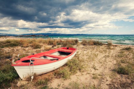 Photo for Seascape with dramatic sky. Boat on the beach - Royalty Free Image