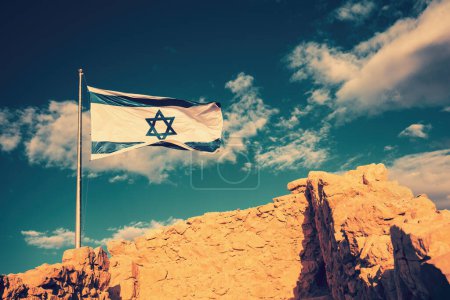 Foto de Bandera de Israel contra el cielo de la mañana. Bandera de Israel en la fortaleza de Masada - Imagen libre de derechos