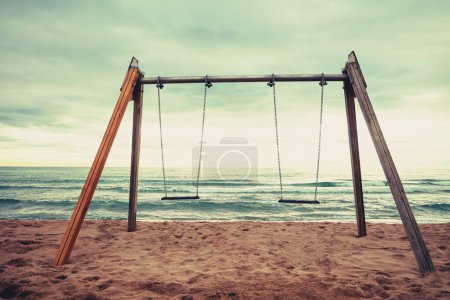 Seascape during sunset. Swing on the beach