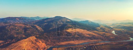 Top view of colorful mountain slopes and river Stryi on a sunny autumn day. Beautiful landscape. Carpathians, Carpathian Ruthenia, Ukraine. Horizontal banner