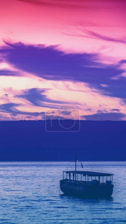 Foto de Hermoso mar de Galilea por la mañana en el norte de Israel. Paisaje marino con el barco durante el amanecer. Color degradado. Banner vertical - Imagen libre de derechos