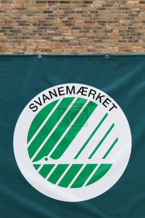 Foto de Horsens, Dinamarca - 13 de mayo de 2021: La marca de cisne nórdica en una pared. La etiqueta ecológica nórdica o cisne nórdico es la etiqueta ecológica oficial de sostenibilidad para los productos de los países nórdicos. - Imagen libre de derechos
