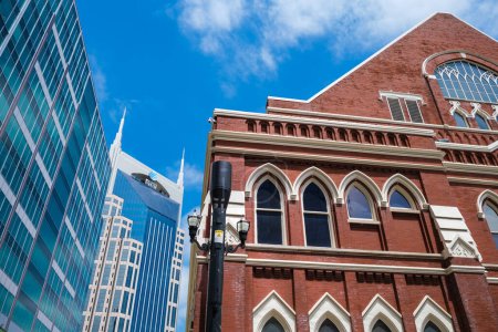 Photo for Nashville, Tennessee USA - May 9, 2022: Downtown cityscape skyline near popular Broadway with modern architecture and the historical Ryman Auditorium - Royalty Free Image