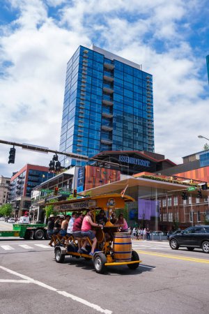 Téléchargez les photos : Nashville, Tennessee USA - May 9, 2022: Downtown cityscape skyline along popular Broadway with visitors enjoying a ride on the Pedal Tavern - en image libre de droit