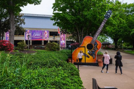 Photo for Nashville, Tennessee USA - May 7, 2022: Tourists taking pictures next to the giant guitar at the entrance to the popular Grand Ole Opry country musiic venue - Royalty Free Image