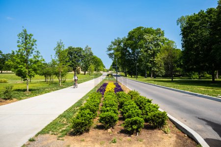 Photo for Nashville, Tennessee - May 10, 2022: Entrance to the popular Centennial Park in with a cyclist passing by in the west end district - Royalty Free Image