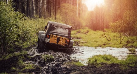 Téléchargez les photos : Véhicule hors route traversant la boue et l'eau. - en image libre de droit