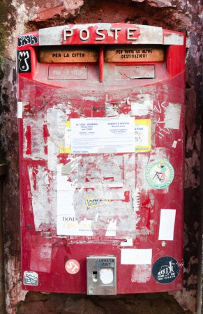 Foto de Nápoles, Campania, Italia - 29 de septiembre de 2022: Buzón rojo antiguo pegado con anuncios en Nápoles, Italia. Orientación vertical - Imagen libre de derechos