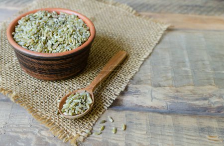 Photo for Raw freekeh or firik in ceramic bowl with spoon on burlap on wooden background. Concept of healthy food. Vegan and vegetarian food. Horizontal orientation. Copy space. - Royalty Free Image