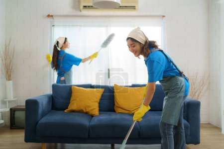 Photo for Two diligent Asian maids collaborate seamlessly, cleaning the living room with precision and efficiency, leaving no corner untouched in their pursuit of spotless perfection - Royalty Free Image