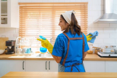 Téléchargez les photos : Femme de ménage comme elle nettoie avec diligence et organise la cuisine à la maison attention méticuleuse aux détails et le dévouement de l'équipe de nettoyage - en image libre de droit