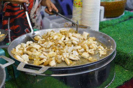 Téléchargez les photos : Des calmars frais frits à la perfection dans une grande casserole dans un marché de street food animé, une collation populaire parmi les habitants et les touristes - en image libre de droit