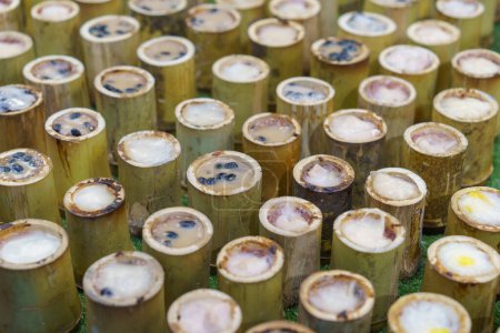 Téléchargez les photos : Délicieux Khao Lam, riz thaïlandais gluant au lait de coco et haricots noirs, cuit à la vapeur dans des tubes de bambou, exposé dans un marché local - en image libre de droit