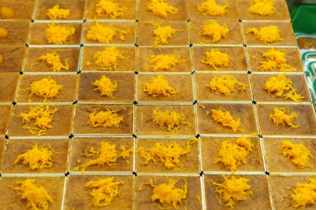 Téléchargez les photos : Dessert thaïlandais uniformément arrangé, Mo Kaeng, avec de petites sphères dorées à base de jaunes d'œufs et de sucre, serti sur une coupe carrée, représentant l'art traditionnel de la fabrication de desserts thaïlandais - en image libre de droit
