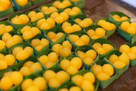 Téléchargez les photos : Kanom Thong Yod, un dessert thaïlandais traditionnel à base de jaunes d'œufs et de sirop de sucre, servi dans des tasses à feuilles de banane - en image libre de droit