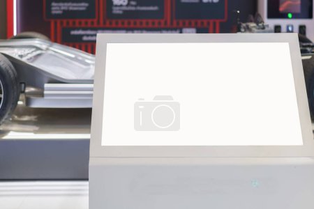 Téléchargez les photos : Modèle d'affichage numérique comportant un écran blanc dans une salle d'exposition de voiture élégante. Cet affichage polyvalent promet des opportunités publicitaires dynamiques - en image libre de droit