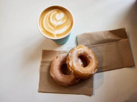 Donut und Kaffee. Eine der am häufigsten konsumierten Süßigkeiten der Welt, von der viele Versionen hergestellt wurden. Dies ist die traditionelle, serviert in einem Café in den Vereinigten Staaten.