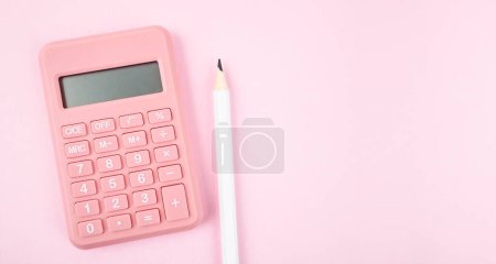 Téléchargez les photos : Calculatrice rose vue de dessus sur fond rose avec copyspace pour le comptage et la planification des dépenses mensuelles concept. - en image libre de droit