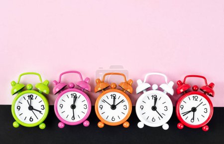 Photo for Many different alarm clocks on pink colour background with copy space for your text or message. - Royalty Free Image