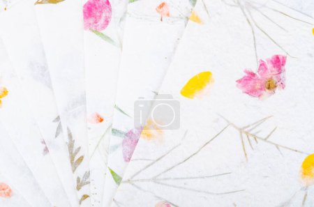 Foto de Montón de diferentes papel hecho a mano con hoja seca y flor. - Imagen libre de derechos