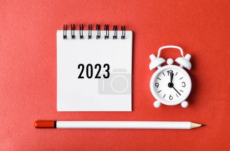 Foto de 2023 calendario de escritorio y despertador con lápiz de madera en cartón rojo. - Imagen libre de derechos