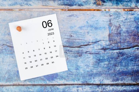 Foto de June 2023 monthly calendar and wooden push pin on blue wooden background. - Imagen libre de derechos