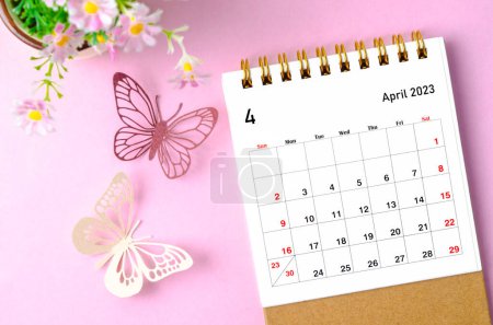 Photo for April 2023 desk calendar for the organizer to plan and reminder and paer butterfly on pink colour background. - Royalty Free Image