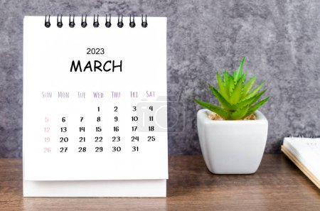 March 2023 Monthly desk calendar for 2023 with diary on wooden table.