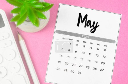 Foto de Mayo 2023 Calendario mensual para 2023 año con calculadora sobre fondo rosa. - Imagen libre de derechos