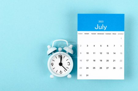 Téléchargez les photos : Juillet 2023 Calendrier mensuel pour 2023 année avec réveil vintage sur fond bleu. - en image libre de droit